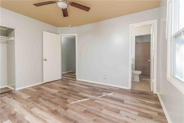 unfurnished bedroom with ensuite bathroom, light hardwood / wood-style floors, ceiling fan, and a closet