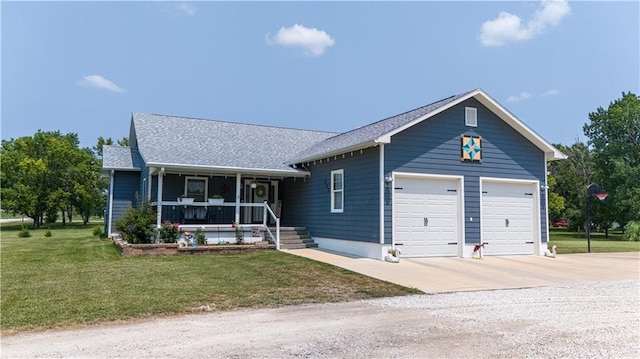 view of front of house featuring a front lawn, a garage, and covered porch