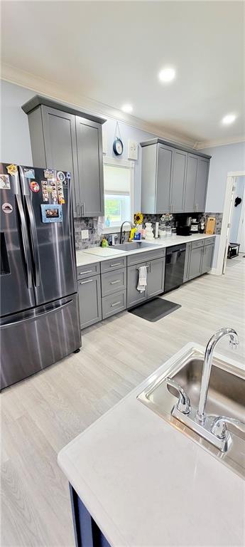 kitchen with gray cabinetry, sink, stainless steel refrigerator, and light hardwood / wood-style flooring