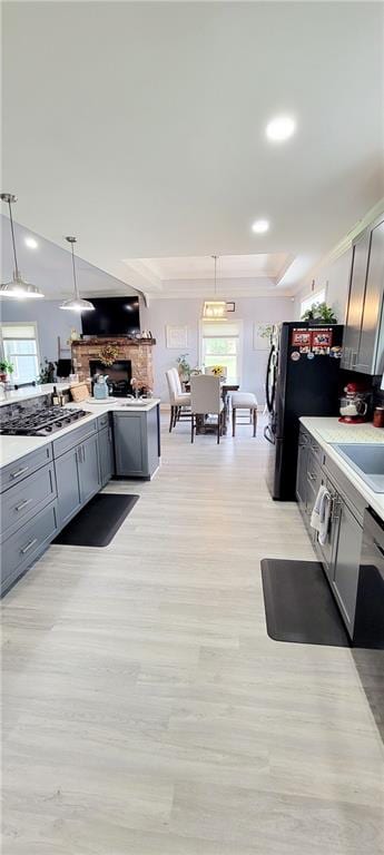 kitchen with gray cabinets, light hardwood / wood-style flooring, and hanging light fixtures