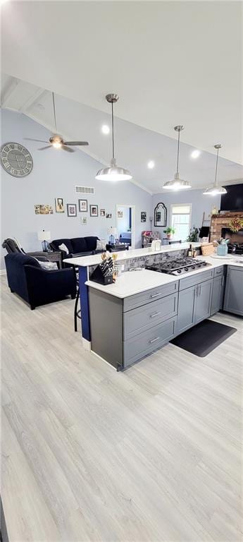 kitchen with light hardwood / wood-style floors, gray cabinets, ceiling fan, pendant lighting, and lofted ceiling with beams