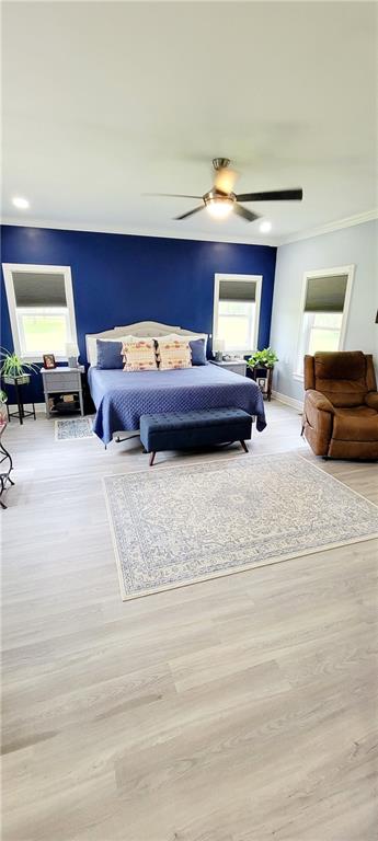 bedroom with light wood-type flooring and ceiling fan