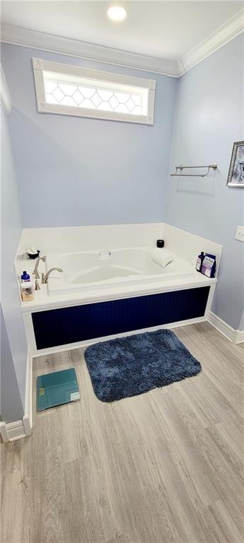 bathroom with a bathtub, wood-type flooring, and crown molding