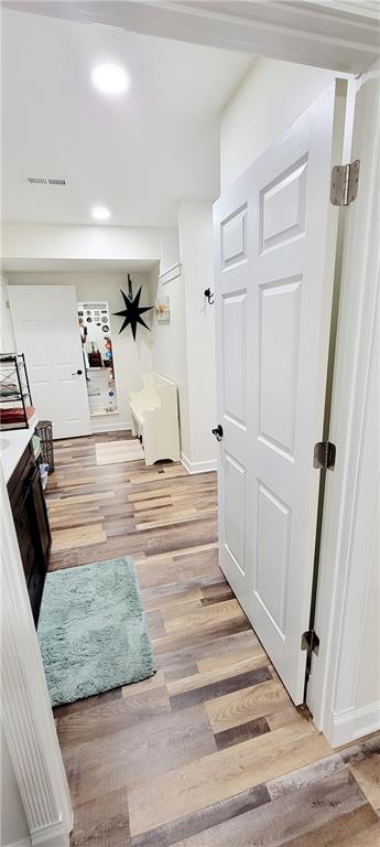 hallway with light hardwood / wood-style floors