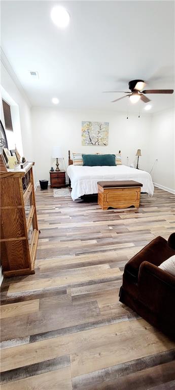 bedroom with light hardwood / wood-style floors and ceiling fan