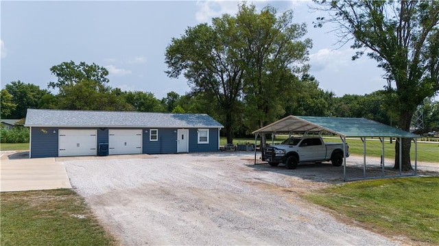 garage featuring a carport and a lawn