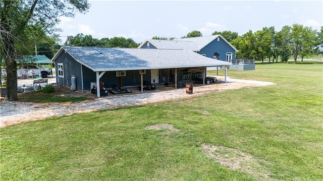 back of property with a yard and a carport