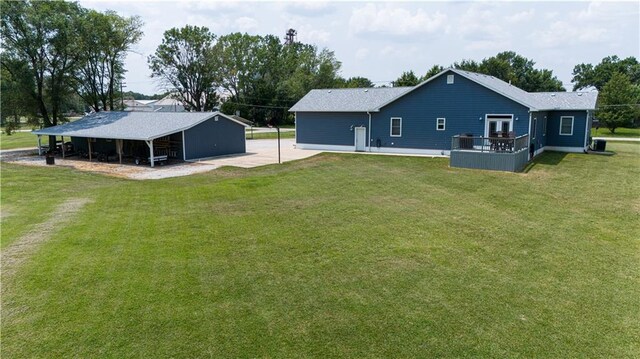 back of property with central AC unit and a lawn