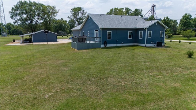 back of house with an outdoor structure, a lawn, and a deck