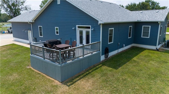 rear view of property with a wooden deck and a yard