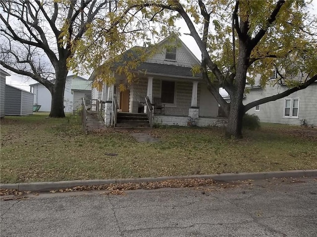 view of front facade featuring covered porch and a front lawn