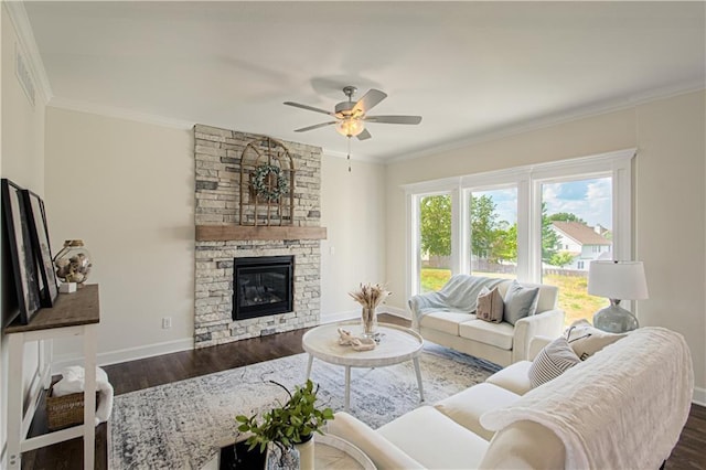 living room featuring dark hardwood / wood-style flooring, a stone fireplace, ceiling fan, and ornamental molding