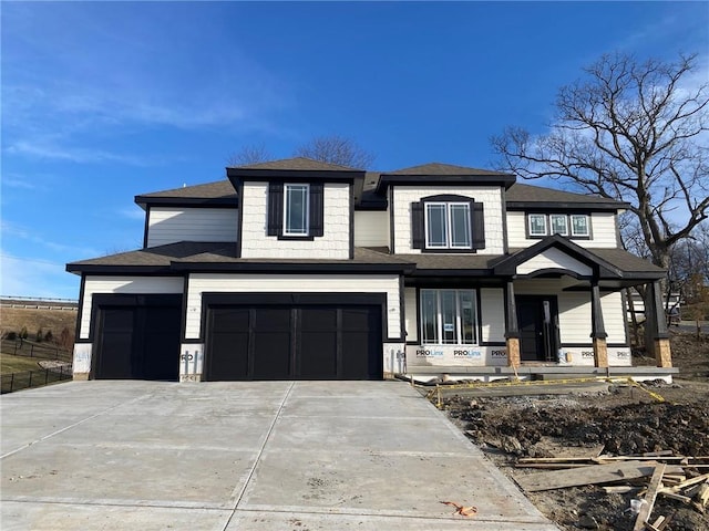 prairie-style home featuring covered porch, an attached garage, concrete driveway, and a garage