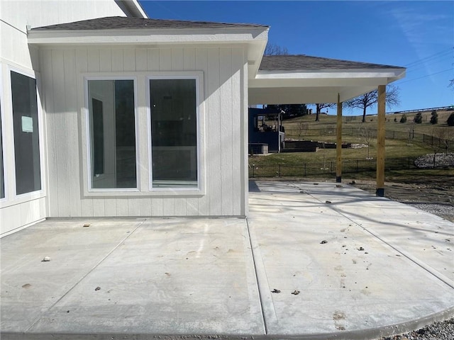 view of patio / terrace with fence and a carport