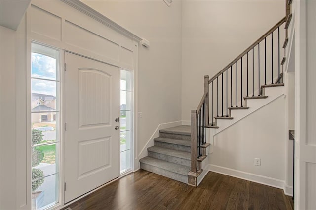 foyer featuring stairs, plenty of natural light, baseboards, and dark wood-type flooring