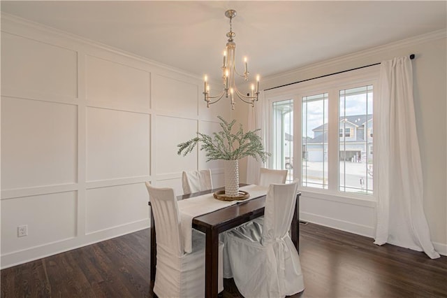 dining room featuring dark wood finished floors, an inviting chandelier, crown molding, and a decorative wall