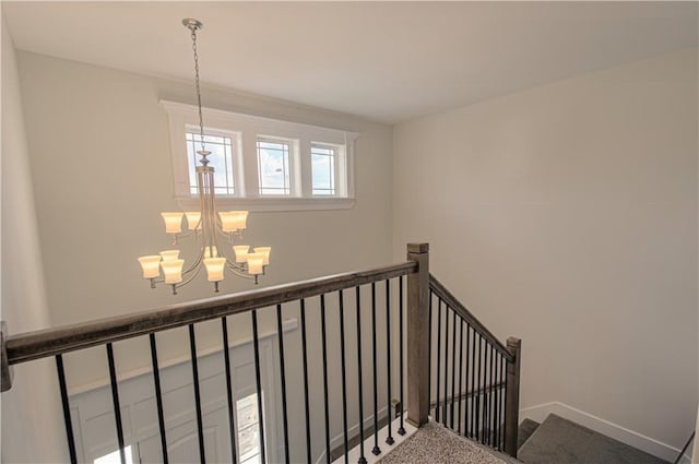 stairway featuring an inviting chandelier and carpet floors