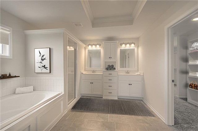 full bathroom featuring a shower stall, a garden tub, crown molding, vanity, and a raised ceiling