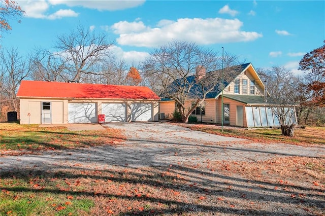 view of front of house with a garage, a front yard, and an outdoor structure