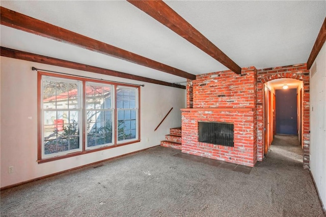 unfurnished living room with carpet flooring, a brick fireplace, and beam ceiling