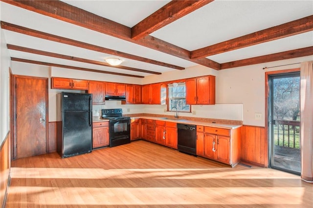 kitchen featuring light wood-type flooring, beamed ceiling, sink, and black appliances