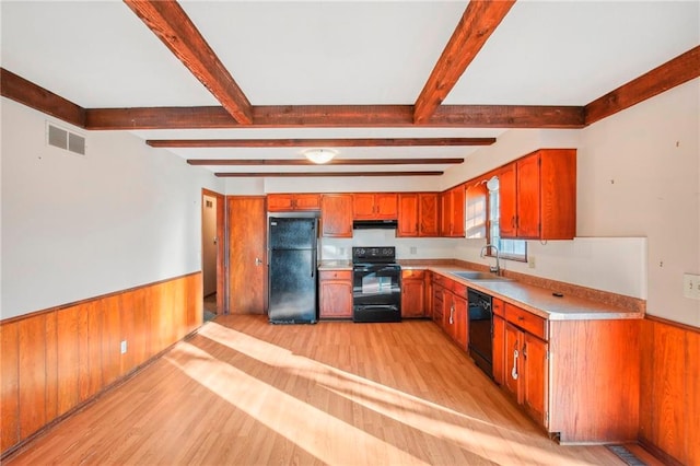 kitchen featuring light hardwood / wood-style floors, beamed ceiling, sink, and black appliances