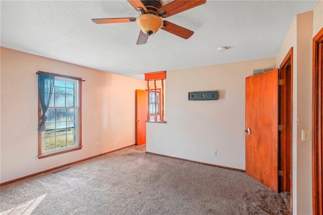 carpeted empty room featuring a textured ceiling and ceiling fan