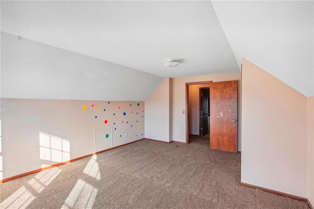 bonus room with vaulted ceiling and carpet floors