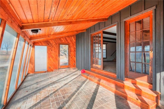 unfurnished sunroom featuring lofted ceiling with beams and wood ceiling