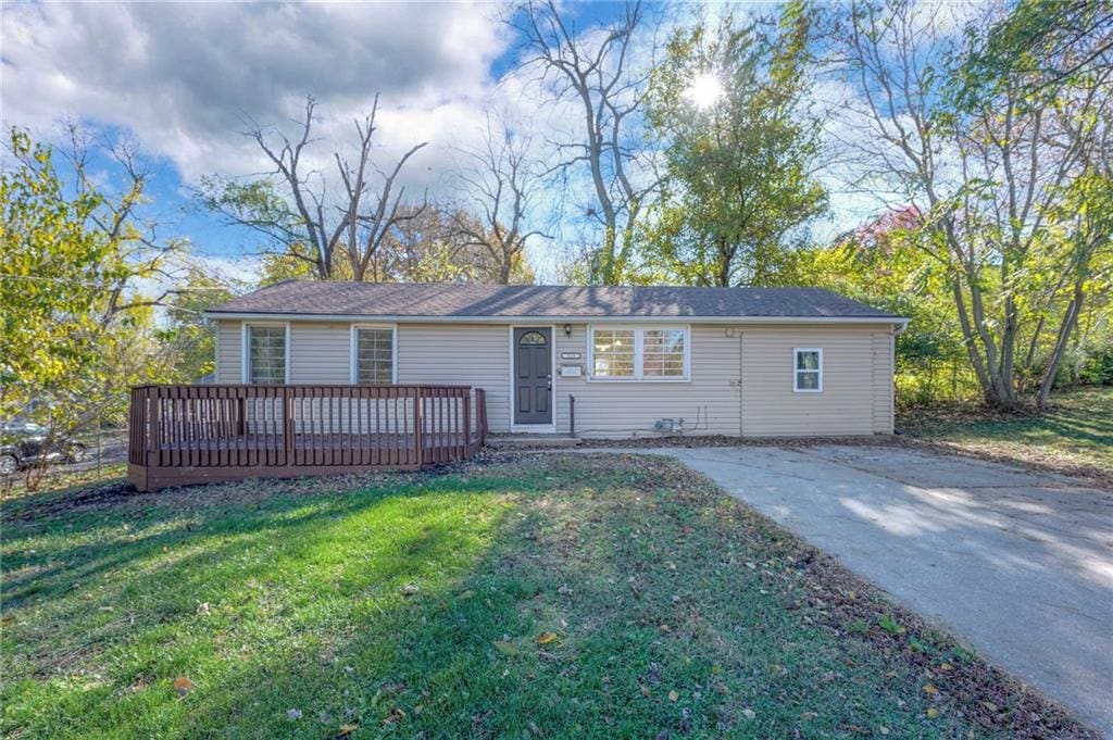 single story home featuring a deck and a front lawn