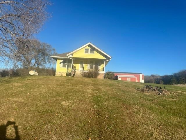 view of front of home featuring covered porch and a front lawn