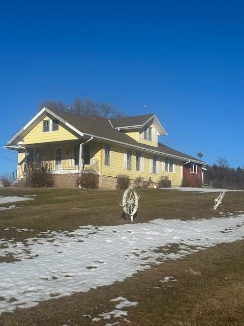 exterior space featuring covered porch and a lawn