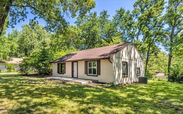 view of front of house featuring central air condition unit and a front lawn