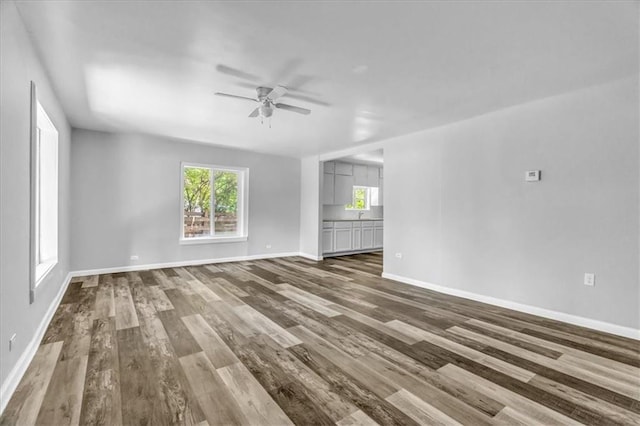 9043 Walnut St, Kansas City, MO 64114 - unfurnished living room with ceiling fan, wood finished floors, and healthy amount of natural light