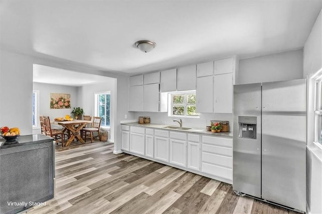 9043 Walnut St, Kansas City, MO 64114 - kitchen featuring stainless steel fridge, light wood finished floors, light countertops, and white cabinetry