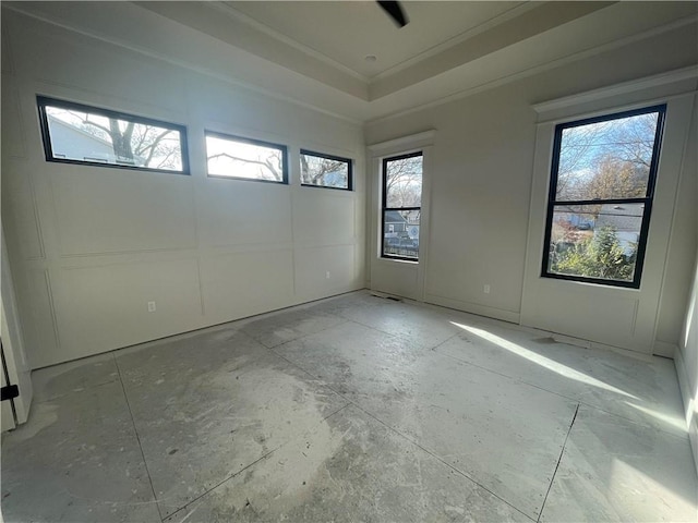 spare room featuring a tray ceiling and crown molding