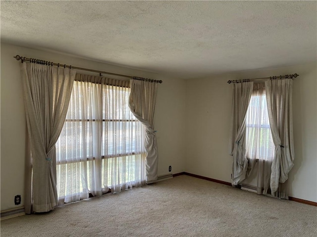 spare room featuring a textured ceiling and carpet