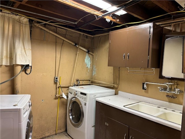 washroom featuring sink, cabinets, and washer and dryer