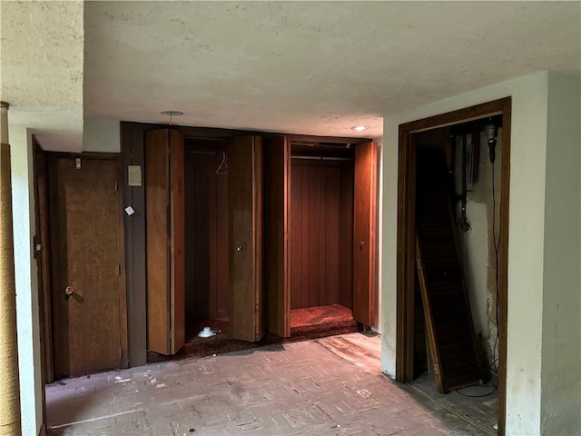 unfurnished bedroom featuring a textured ceiling and wood walls