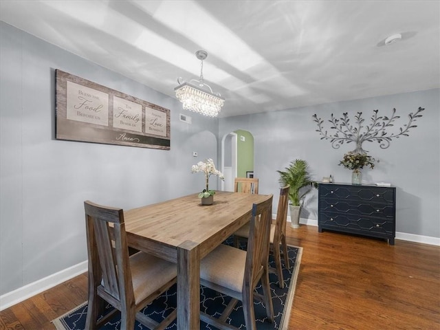 9317 Gillette St, Lenexa, KS 66215 - dining space featuring arched walkways, wood finished floors, and a chandelier