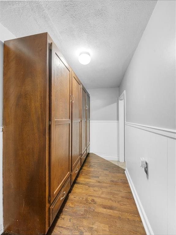9317 Gillette St, Lenexa, KS 66215 - corridor with a textured ceiling, wood finished floors, and a wainscoted wall
