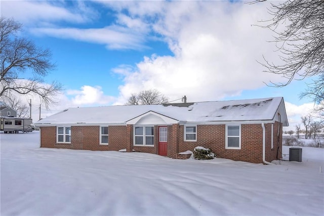 snow covered house with central AC unit