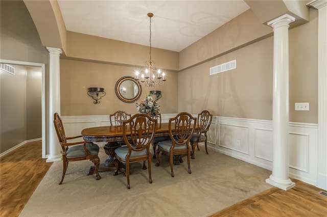 dining space featuring ornate columns and hardwood / wood-style floors