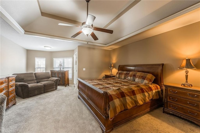 bedroom featuring ornamental molding, light colored carpet, ceiling fan, and a tray ceiling