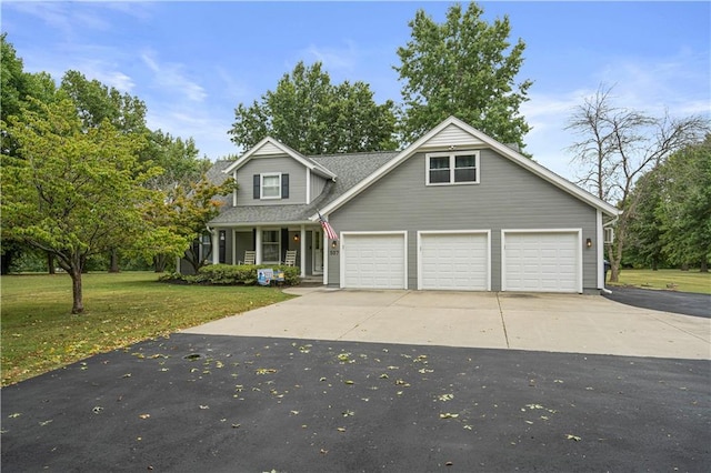 view of front of house with covered porch, a garage, and a front lawn