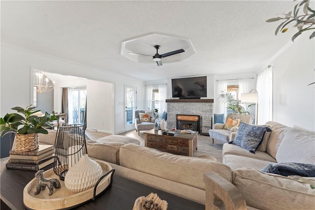 living room with crown molding, light hardwood / wood-style floors, and ceiling fan with notable chandelier