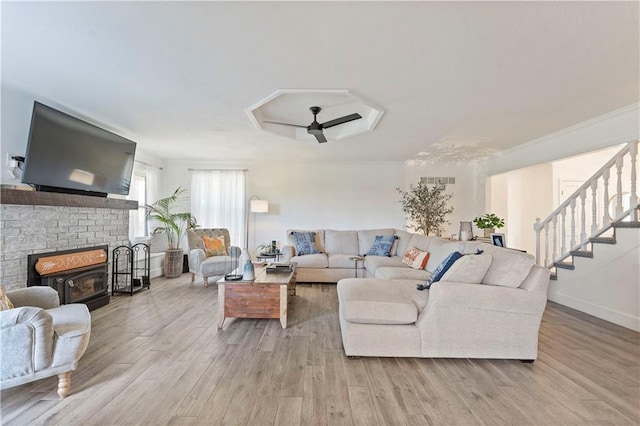 living room with ceiling fan, light hardwood / wood-style floors, and a brick fireplace