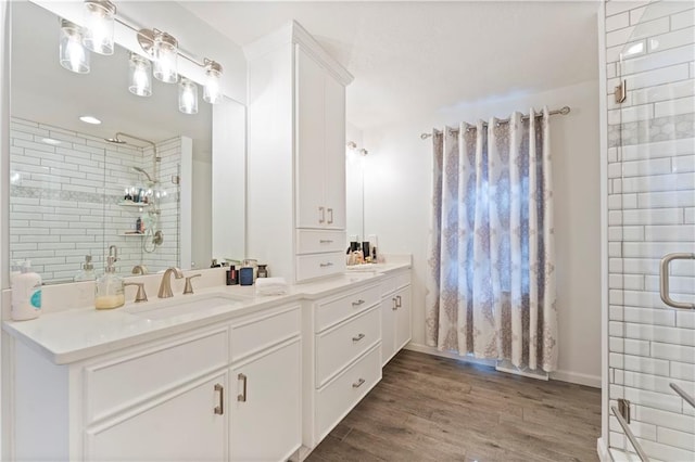 bathroom featuring vanity, wood-type flooring, and a shower with shower door