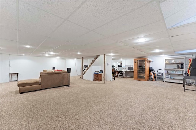 carpeted living room featuring a drop ceiling