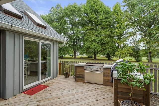 wooden terrace with an outdoor kitchen and a grill